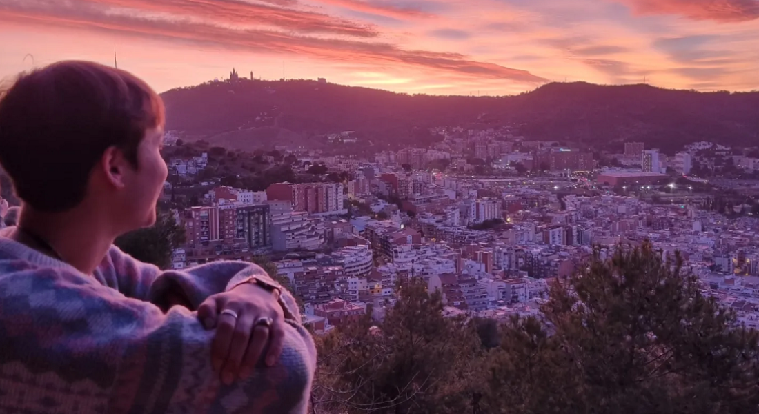 Une étudiante devant un coucher de soleil à Barcelone en Espagne