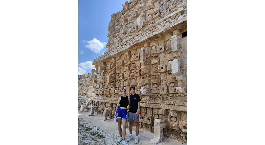 Une étudiante et un étudiant devant Ruta Puuc, monument historique de la ville de Mérida au Mexique