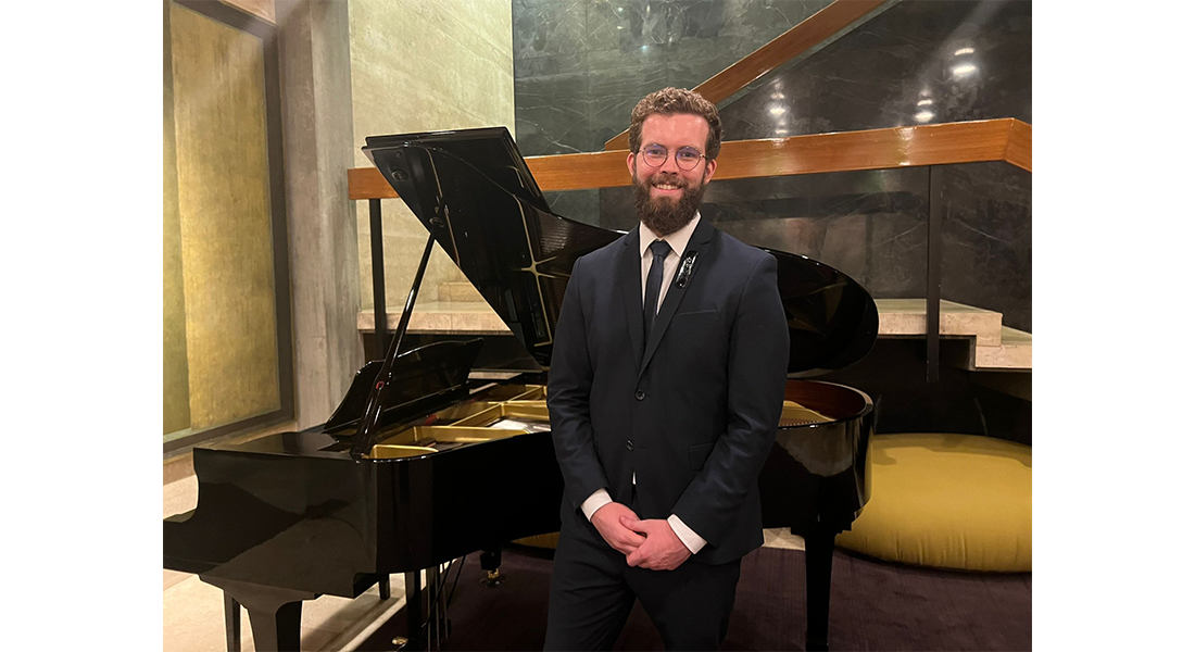 Un étudiant devant un piano à queue