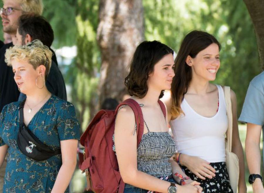 Photo d'étudiants et étudiantes de l'ENTPE, souriants, debout sous des arbres, en train de discuter 